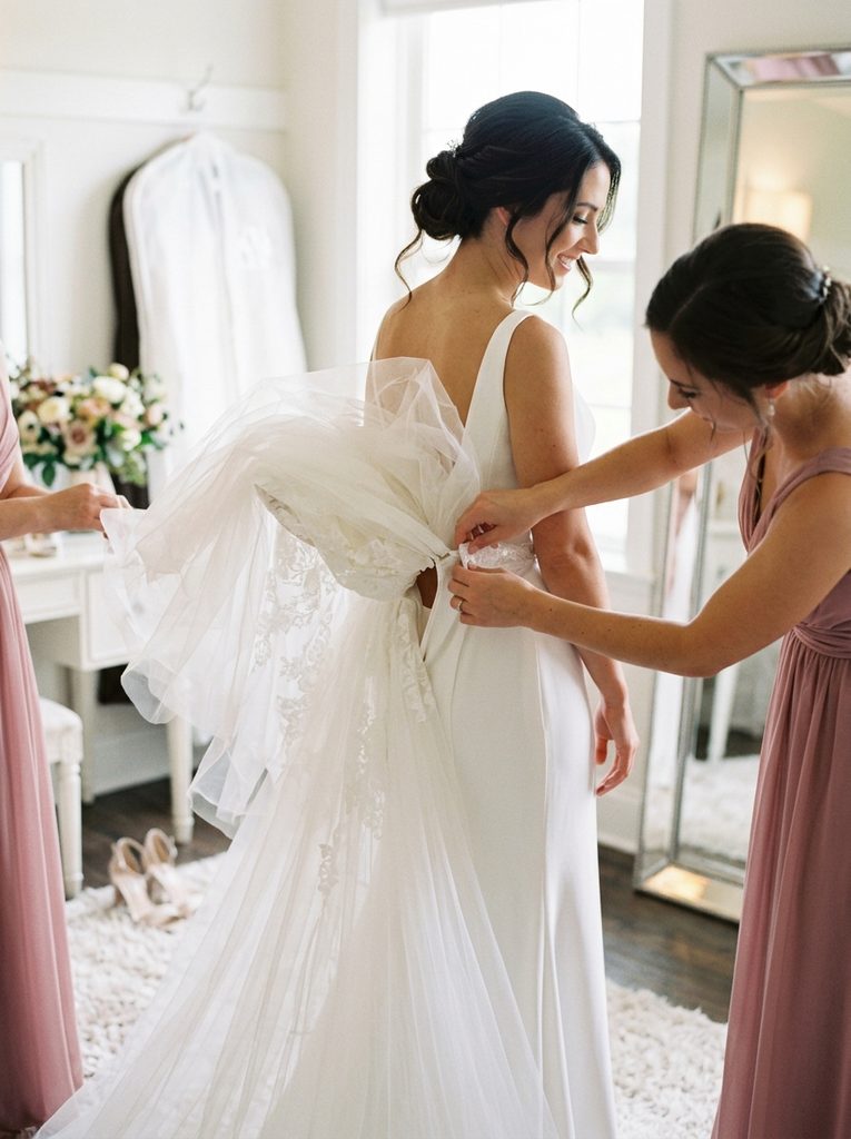 Detachable overskirt being removed from a convertible wedding dress