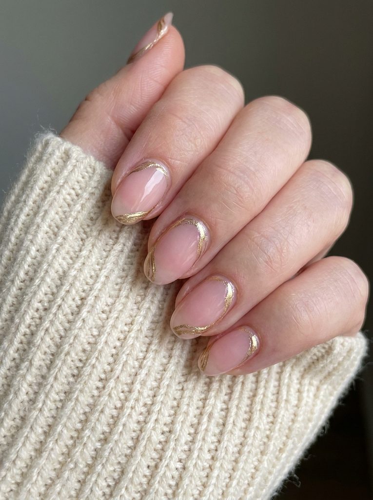 Hand with delicate hand-painted gold linework along the nail cuticle