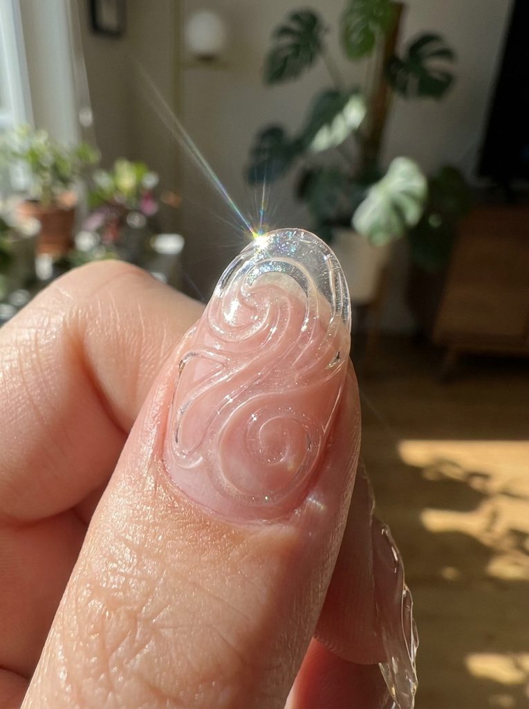 Nail with fine raised gel linework catching light on the surface