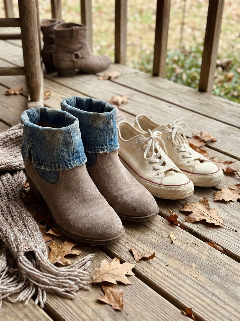 Suede ankle boots next to canvas sneakers for early fall footwear