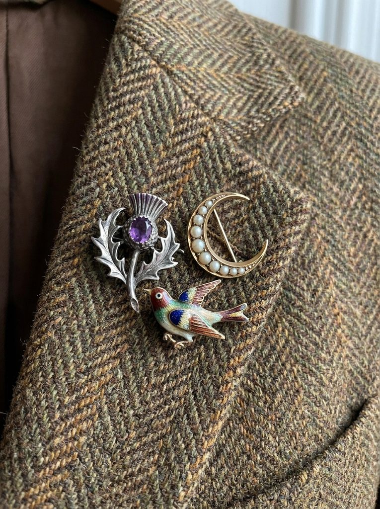 Cluster of three small brooches on a brown tweed lapel